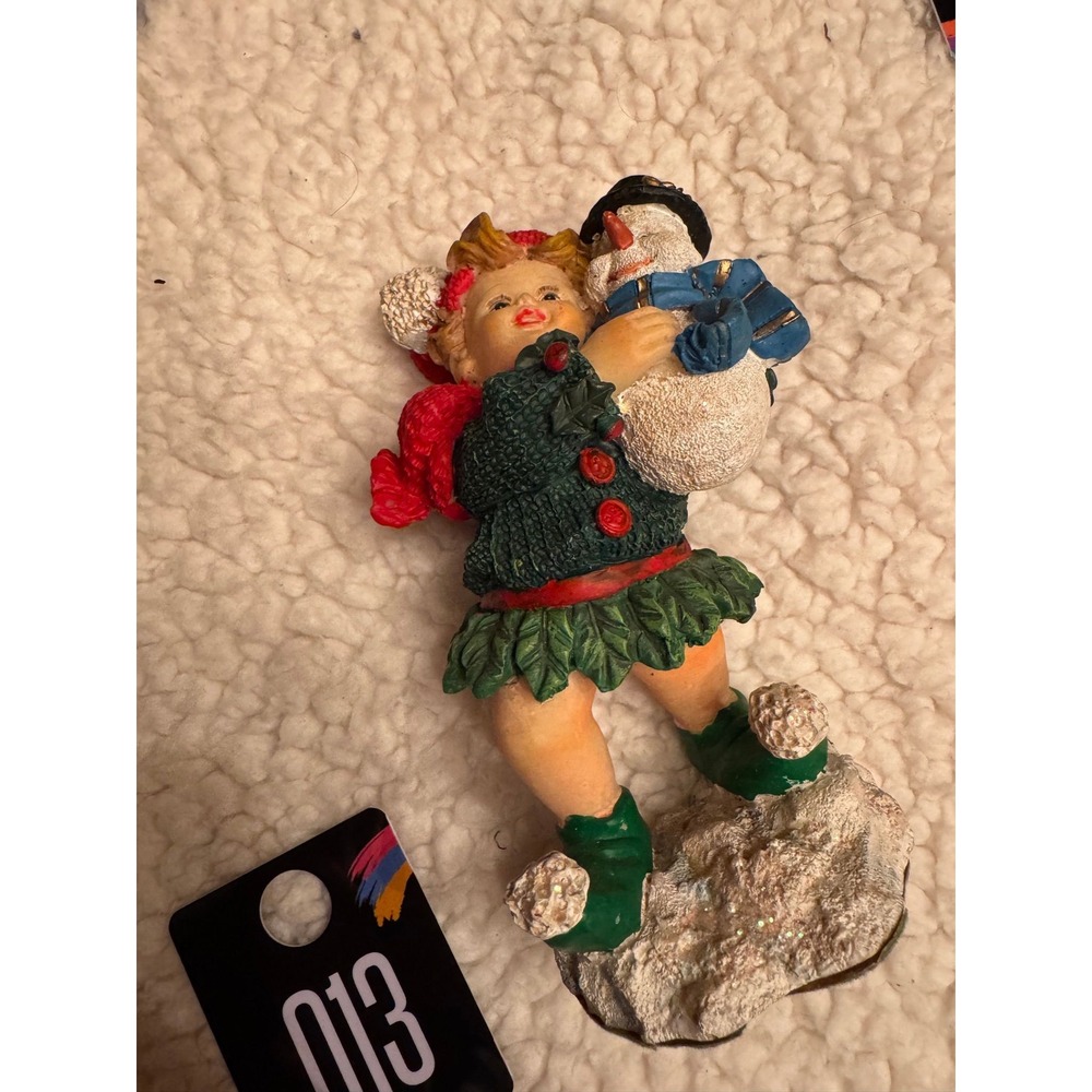 Lil girl carrying snowman figurine